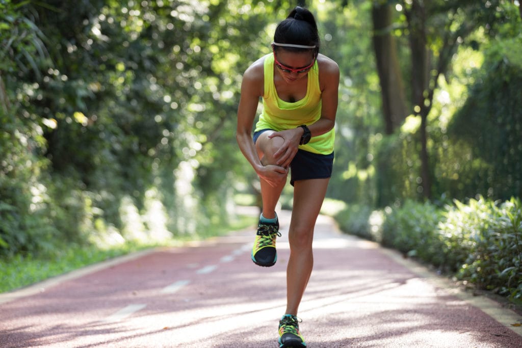 Female runner suffering with pain on sports running knee injury
