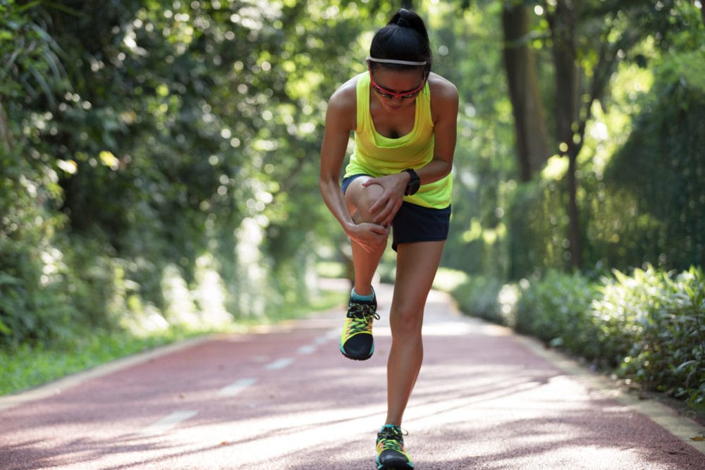 Female runner suffering with pain on sports running knee injury