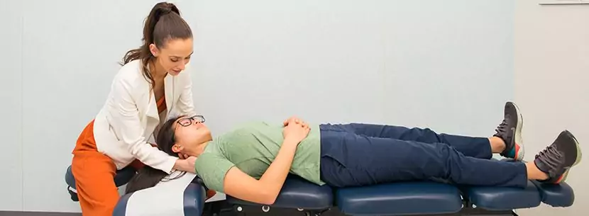 chiropractor examining patients neck shoulders