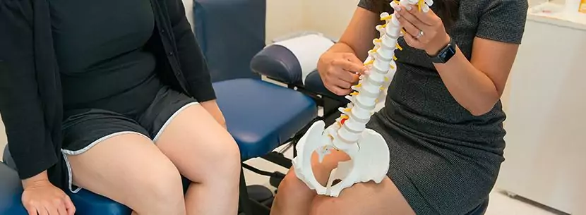 chiropractor pointing to spine model
