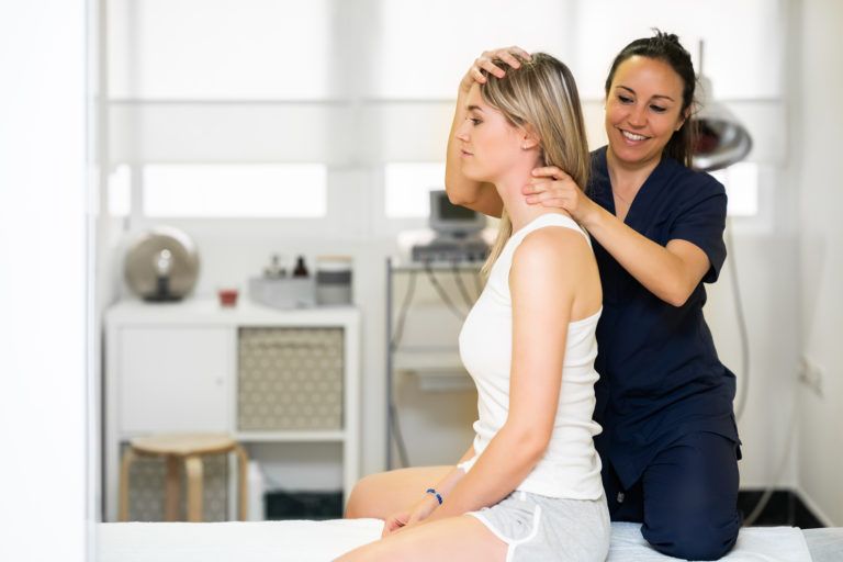 physiotherapist inspecting patients neck